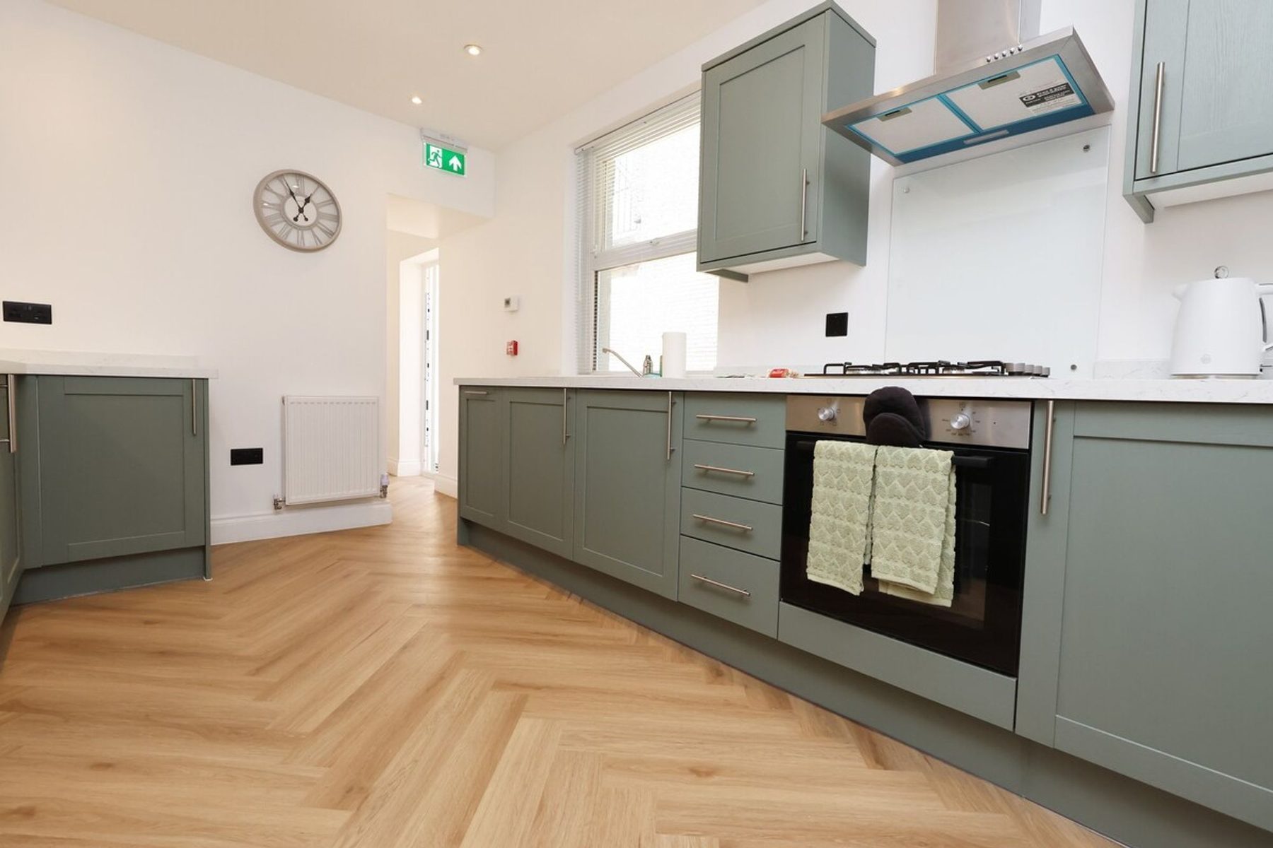 The sage green kitchen of an EKLiving shared house in Swansea